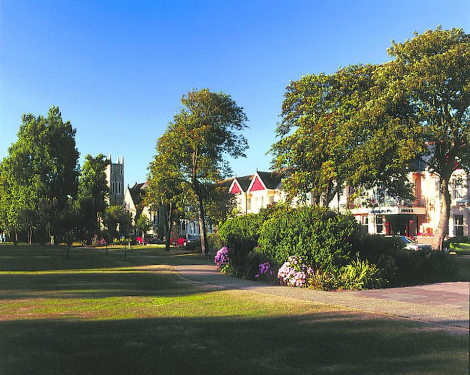 un parque con una casa y algunos arbustos y árboles en Ardington Hotel, en Worthing