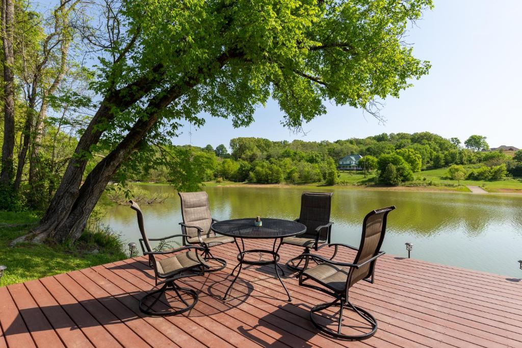 a table and chairs on a wooden deck next to a lake at Sunrise Cove in Dandridge