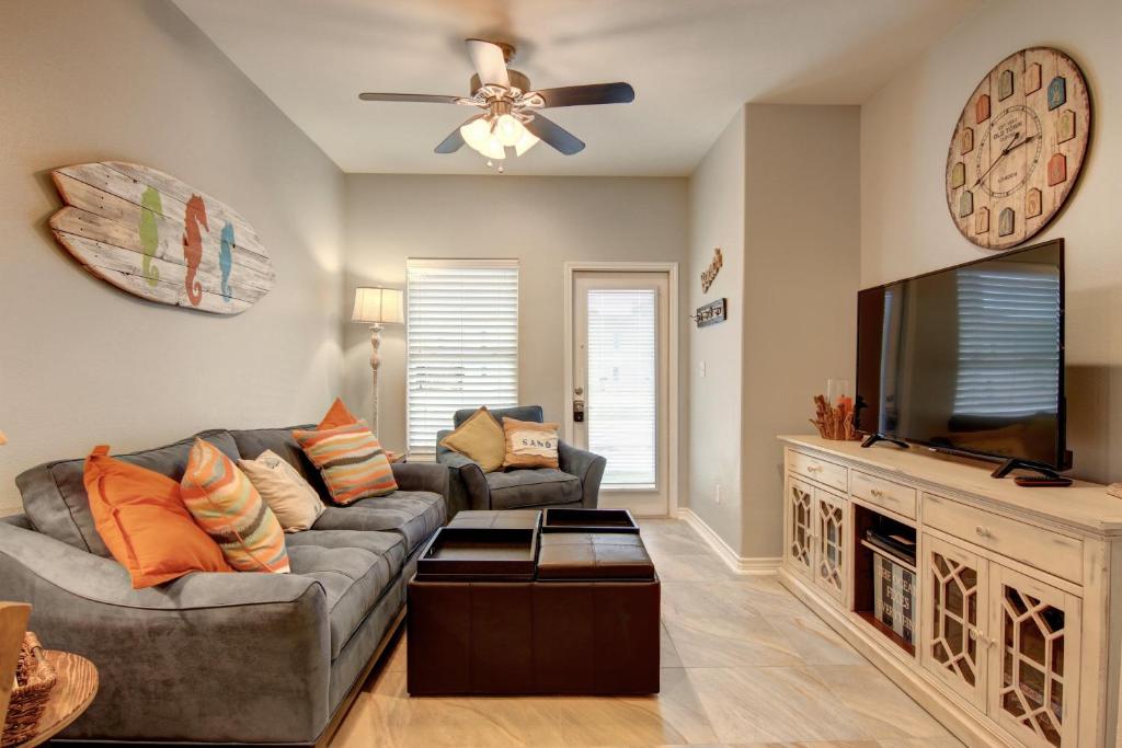 a living room with a couch and a flat screen tv at Surfin Seahorse in Port Aransas