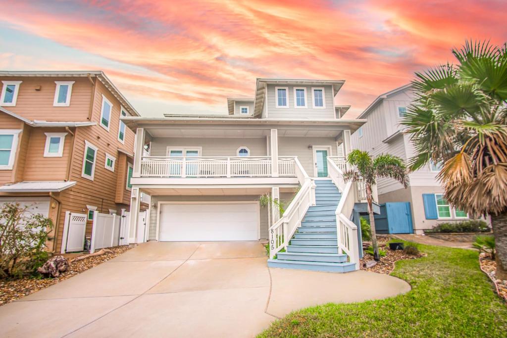 a house with a driveway and palm trees at Itll Do in Padre Island