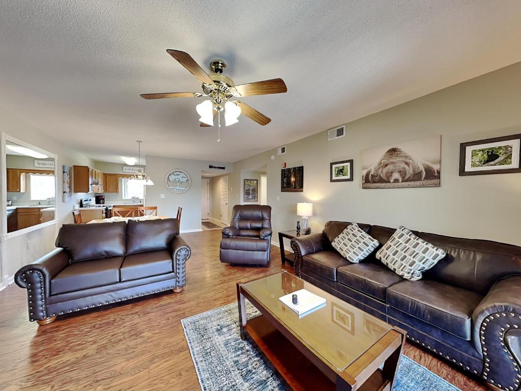 a living room with leather furniture and a ceiling fan at Paradise Pines Whispering Pines 133 in Pigeon Forge