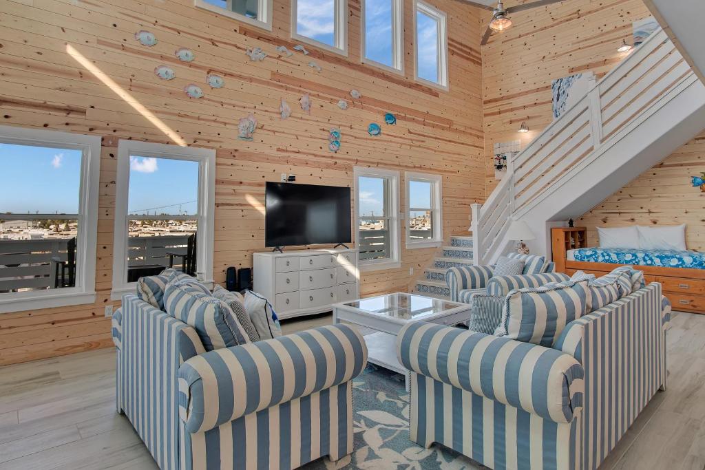 a living room with chairs and a flat screen tv at Ocean Spirit in Port Aransas