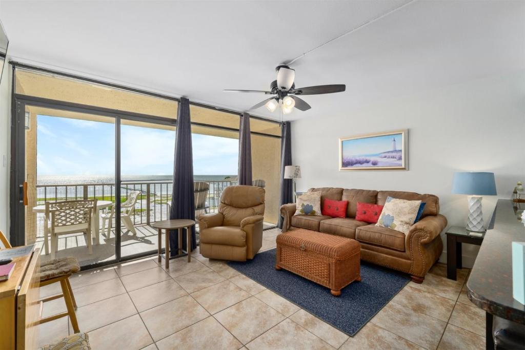 a living room with a couch and chairs and a balcony at Laguna Reef #315 - Bayview Retreat in Rockport