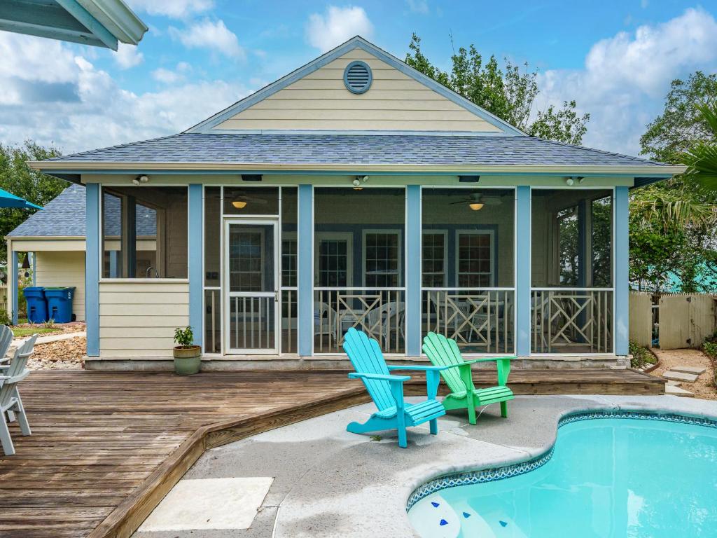 a home with a pool and two chairs and a house at Magnolia Cottage in Rockport