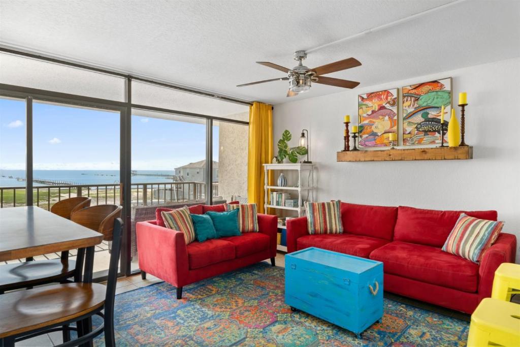 a living room with a red couch and a table at Laguna Reef #215 - Tequila Sunrise in Rockport