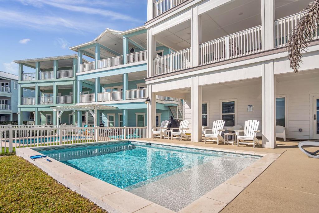 a building with a swimming pool in front of a house at The White House in Padre Island
