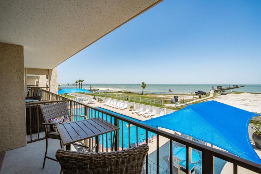 a balcony with chairs and a view of the beach at Laguna Reef #211 - Rod and Reel in Rockport