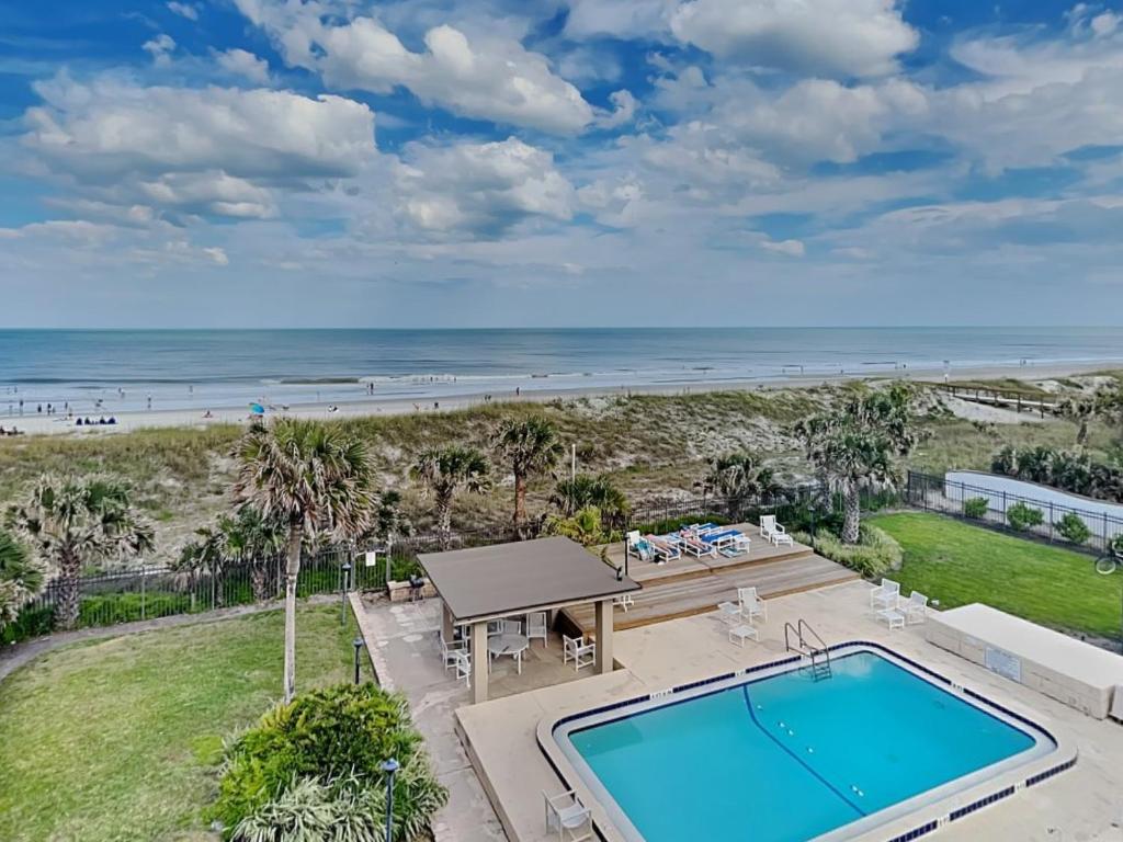 an overhead view of a swimming pool and the beach at Beachcomber 403 in Jacksonville Beach