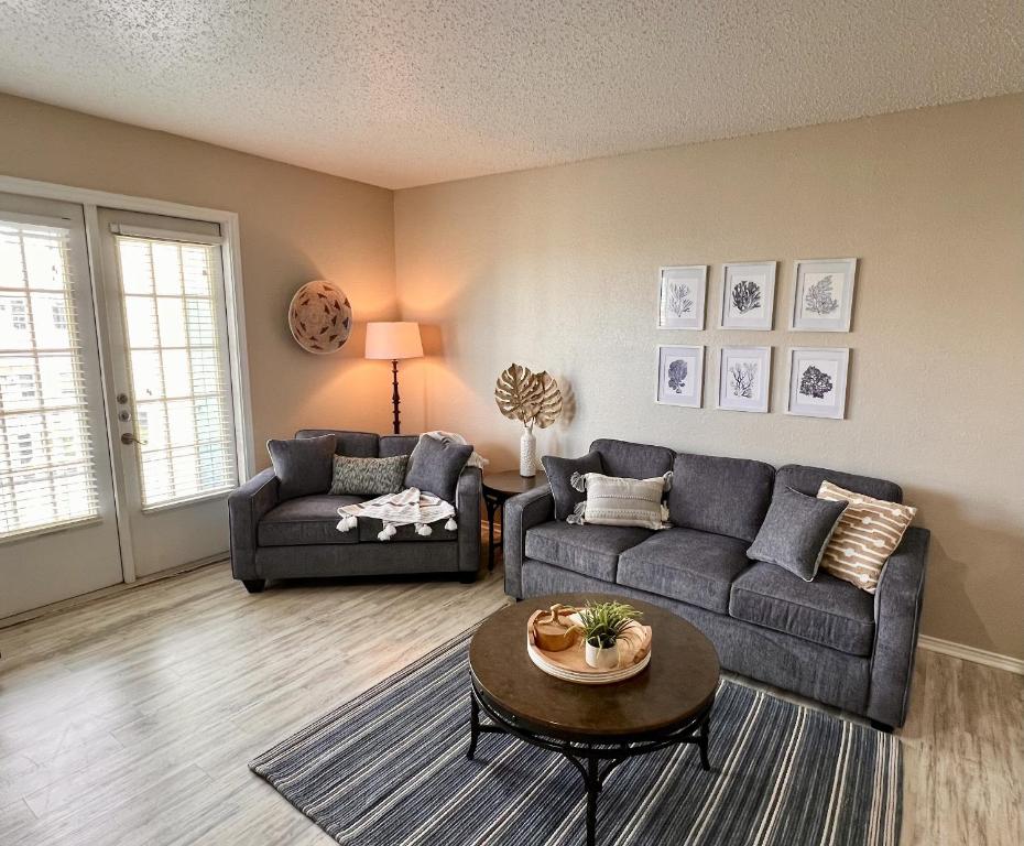 a living room with two couches and a table at Toes In The Water II in Padre Island