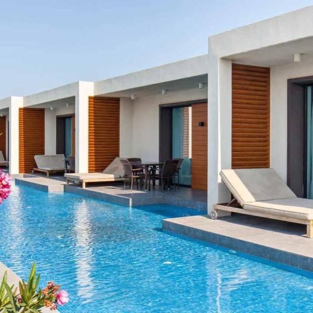 a resort with a swimming pool with beds and chairs at SeaBreeze White Villa 42 in Nardaran