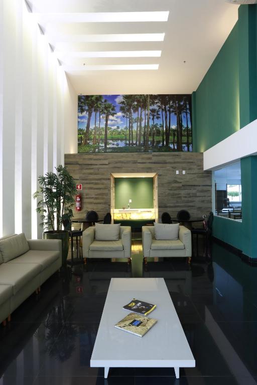 a living room with a couch and a tv at Uchôa Teresina Hotel in Teresina