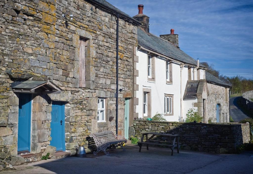 a stone building with a bench in front of it at Widewath Barn in Penrith