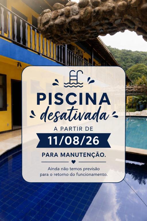 a sign in front of a building with a swimming pool at Bella Pousada in Abraão