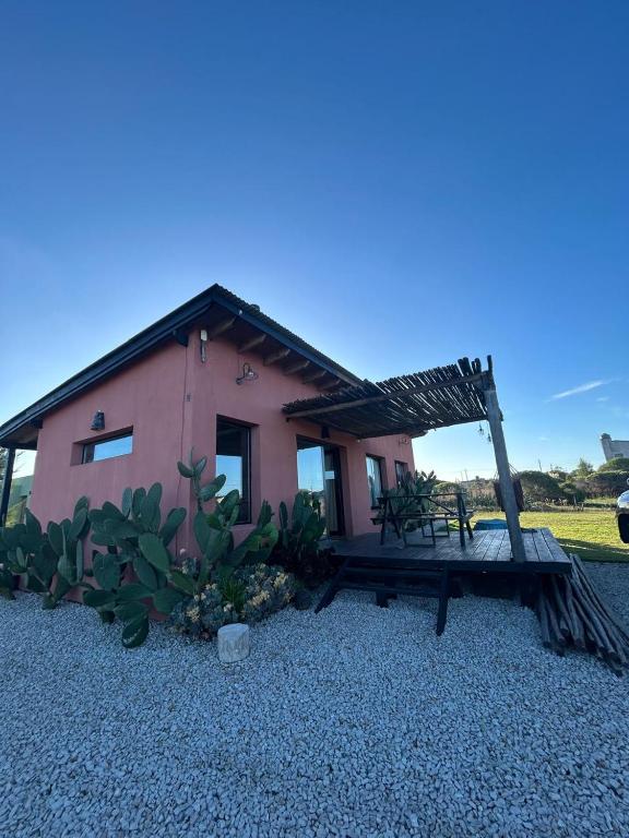 a small pink house with a bench in front of it at Lalau Casa de Playa in Chapadmalal