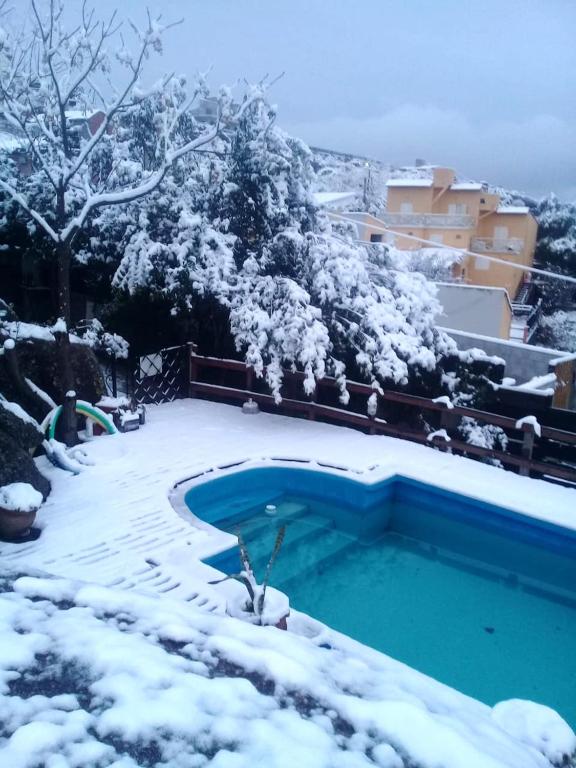 a swimming pool covered in snow next to a building at CABAÑAS BALCON DE PEHUMAYEN in Villa Carlos Paz