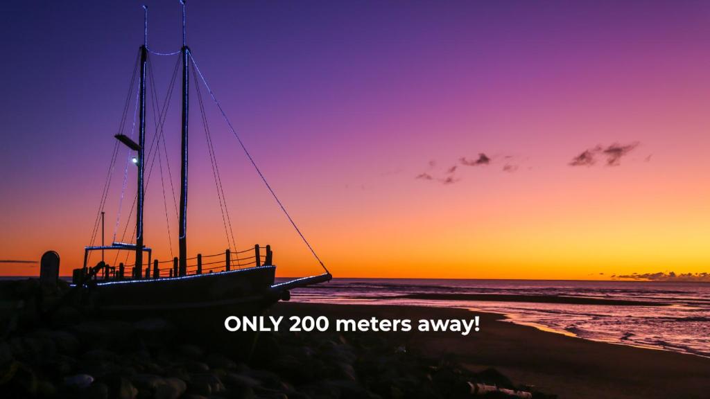 a boat sitting on the beach at sunset at Sunset View Point in Hokitika