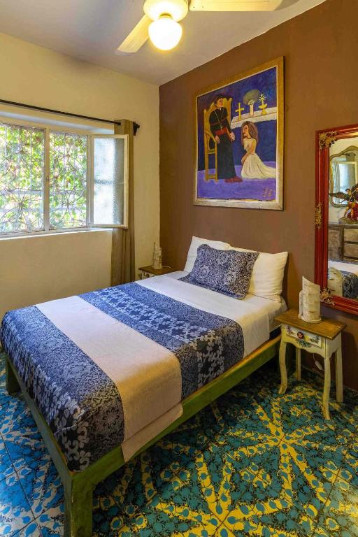 a bedroom with a bed and a painting on the wall at Suites El Refugio zona Céntrica frente al Tren ligero linea 1 in Guadalajara