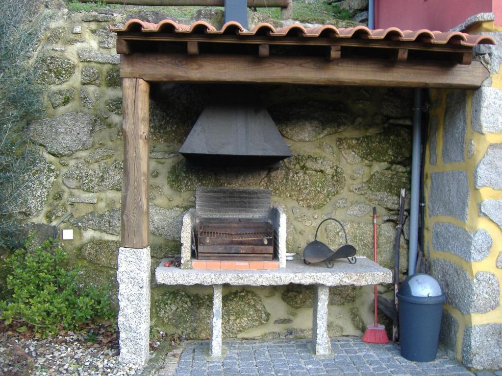 a table with a stove in a stone building at Chalé da Fonte - T2 in Geres