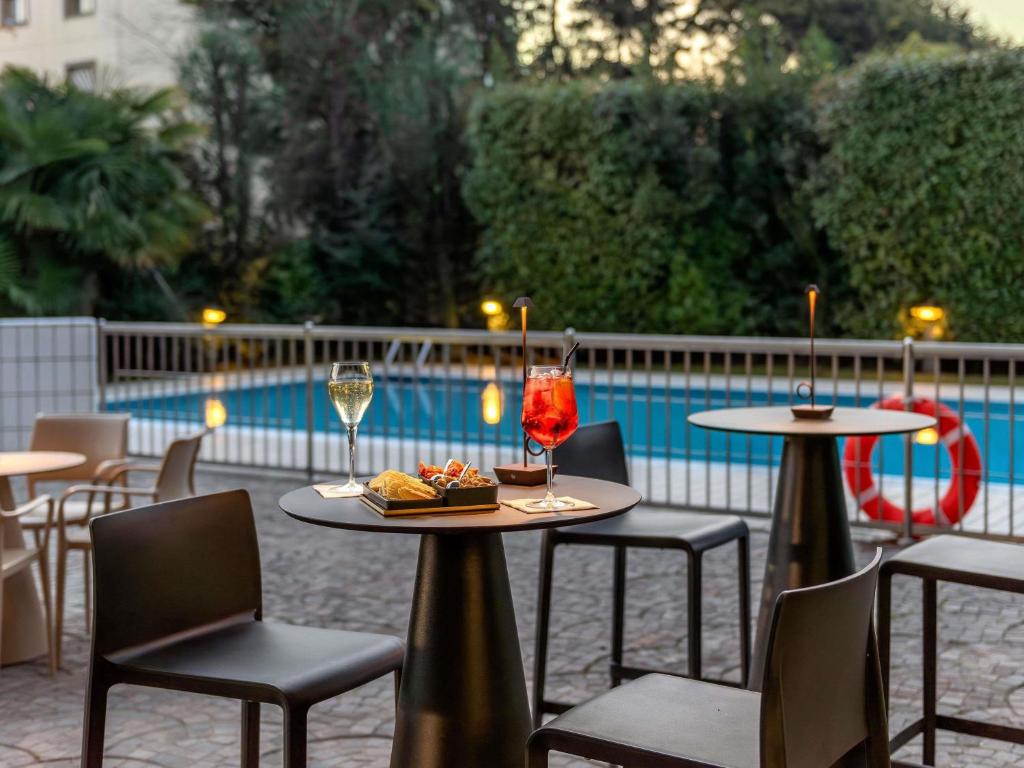 a table with a plate of food and glasses of wine at Novotel Brescia Due in Brescia
