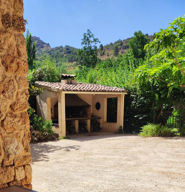 a small house with a porch with mountains in the background at Casas Rurales Ribera de Salobre in Salobre