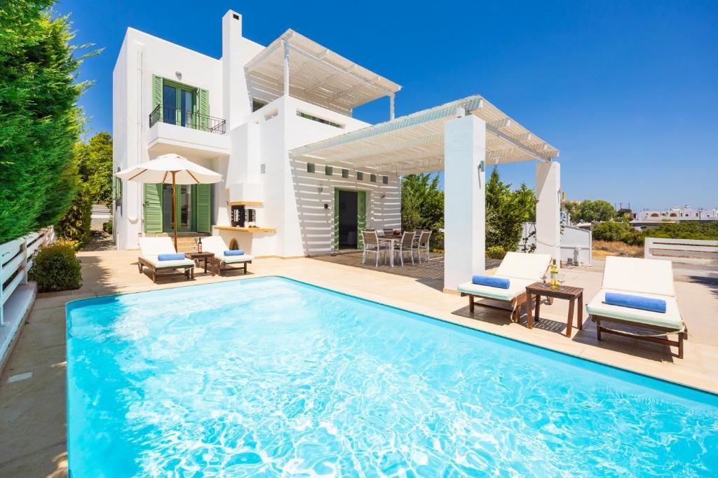 a villa with a swimming pool in front of a house at Villa Loka in Gennadi
