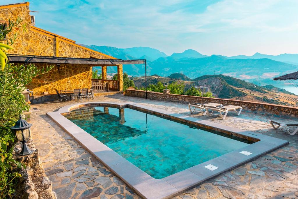 a house with a swimming pool with mountains in the background at El Valle Dorado in El Gastor