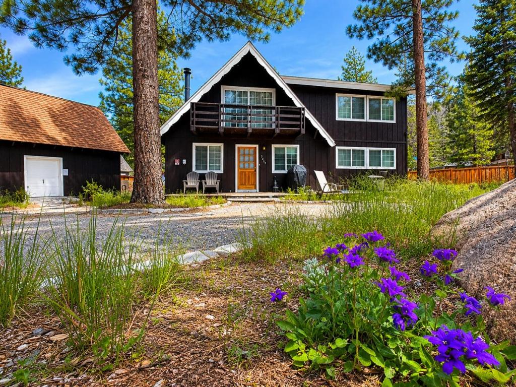 a house with a porch and flowers in the yard at Panorama Chalet in Nebelhorn