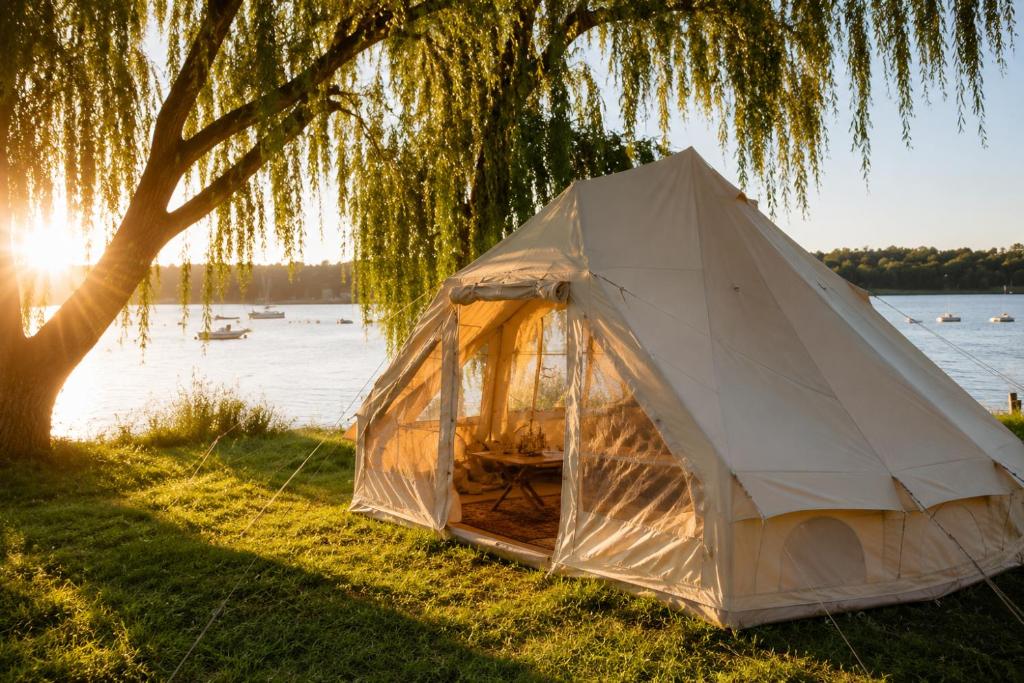 a white tent under a tree next to a lake at Superbe Tente Luxeuse in Neuilly-sur-Marne