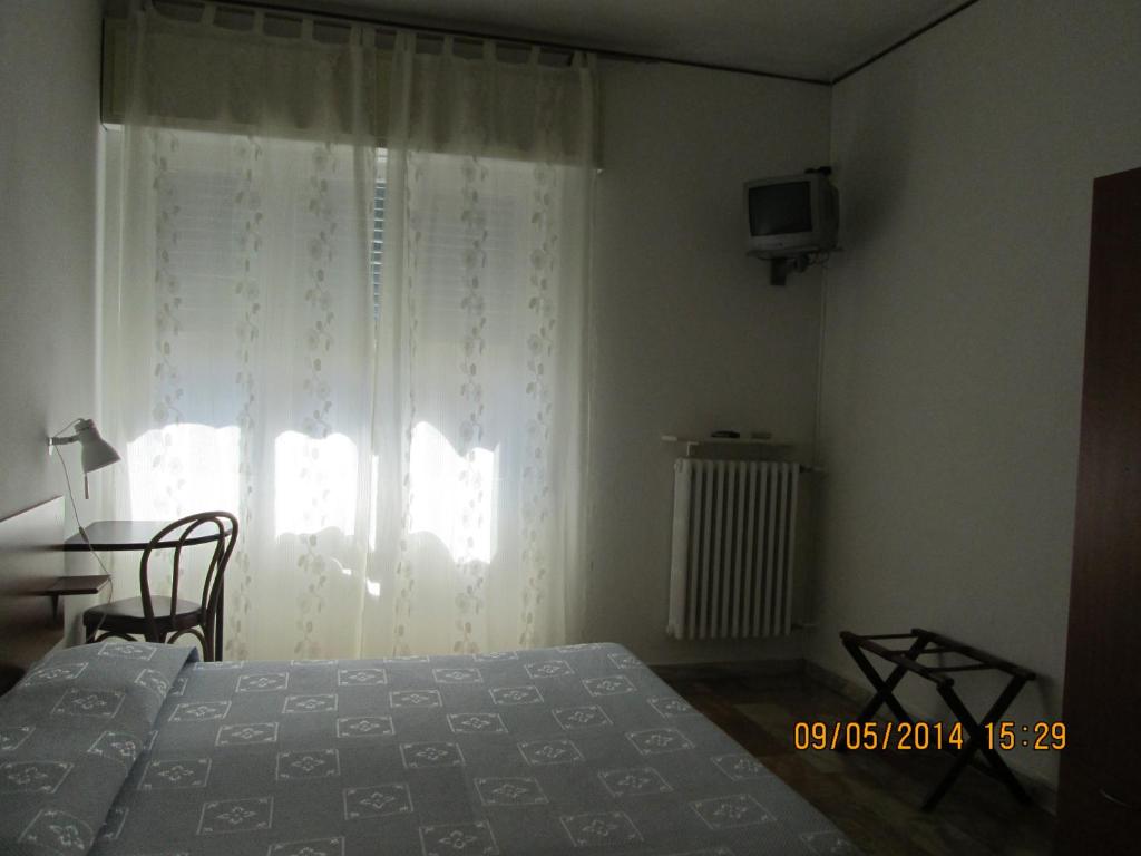 a bedroom with a bed and a window and a television at Pensione Aurora in Imperia