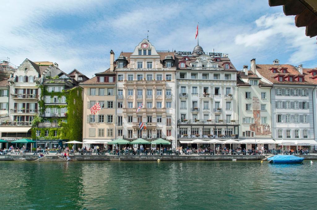 um grande edifício ao lado de uma massa de água em Hotel Pickwick and Pub "the room with a view" em Lucerna