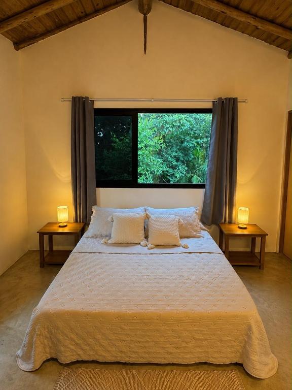 a bedroom with a bed and a large window at Suíte em Trindade, Praia Brava, na Mata in Paraty