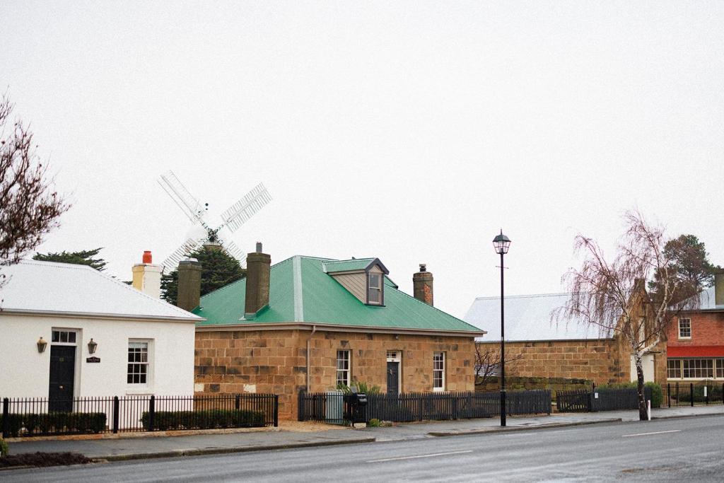 a house with a green roof and a windmill at 101 Oatlands Tasmania in Oatlands