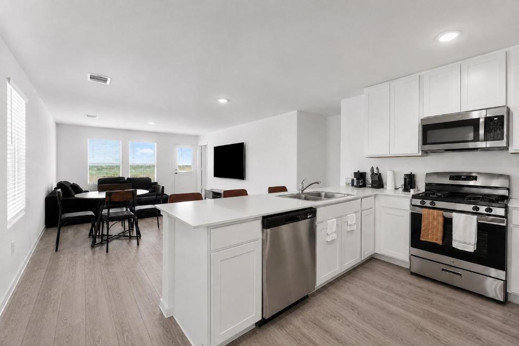 a kitchen with white cabinets and a dining room at 3BR Near Gruene Historic District, Comal, and Guadalupe Rivers & Schlitterbahn in New Braunfels