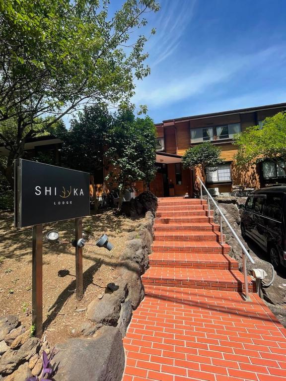 a building with a sign in front of it at Shika Lodge Izu in Ito
