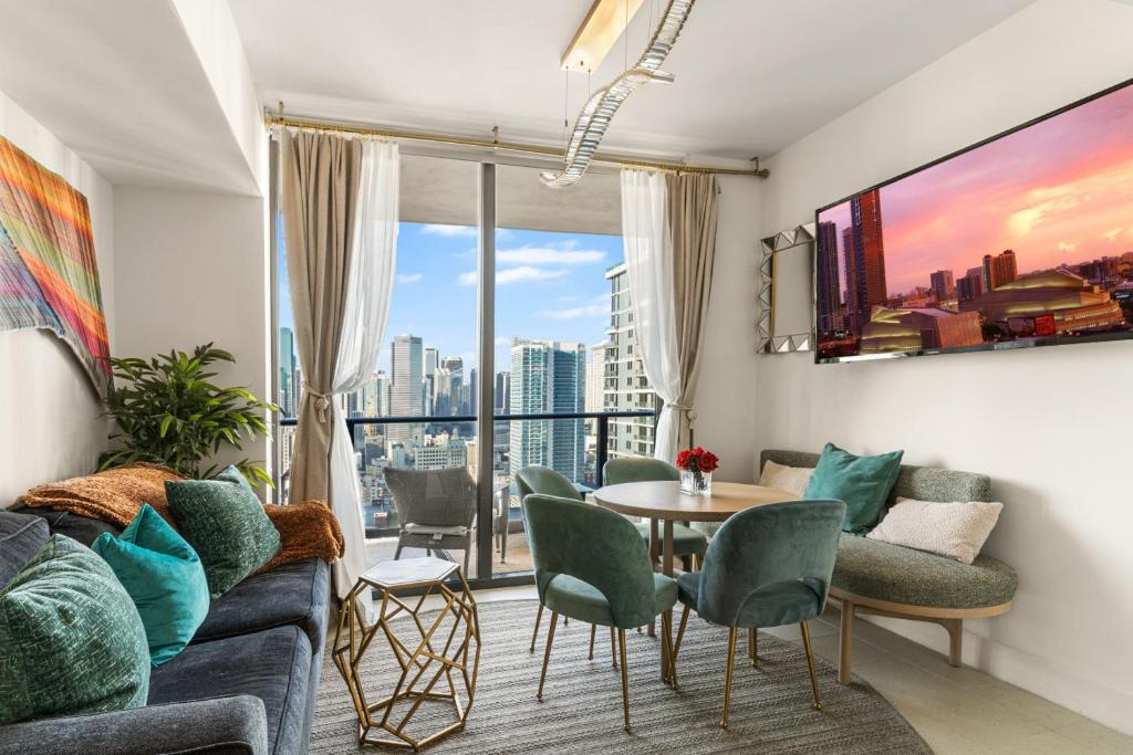 a living room with a couch and a table and chairs at Miami Luxe Sky 27 Skyline View Stunning Water & City Lights View, Resort Pool,Gym,Spa Restaurants in Miami