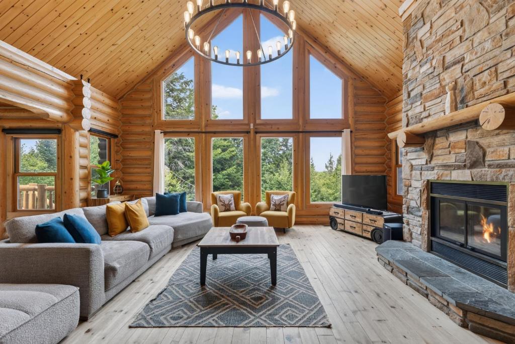 a living room with a stone fireplace and a tv at Fiddler Lake Resort - Deer 87 in Mille-Isles
