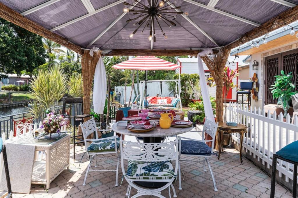 a patio with a table and chairs and an umbrella at Luxury Waterfront Villa, With Private Hot Tub, Beachs, Aventura Mall Casinos, Restaruants in Hallandale Beach