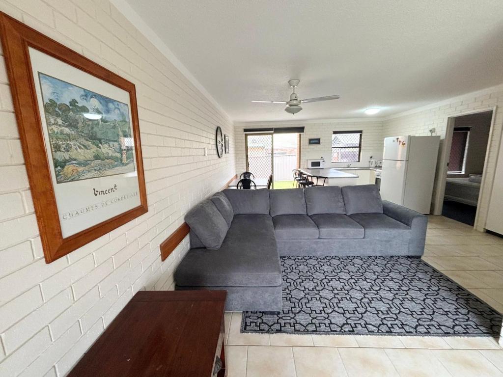 a living room with a couch and a kitchen at Cameo Court 1 in South West Rocks