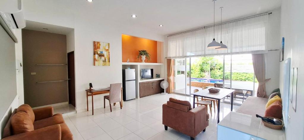 a living room with a kitchen and a dining room at Pranburi Private Pool Villa Baan Prae by Baan Chaylay in Pran Buri