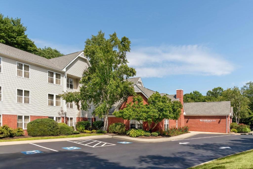 a house with a tree and a parking lot at Residence Inn Mystic Groton in Mystic