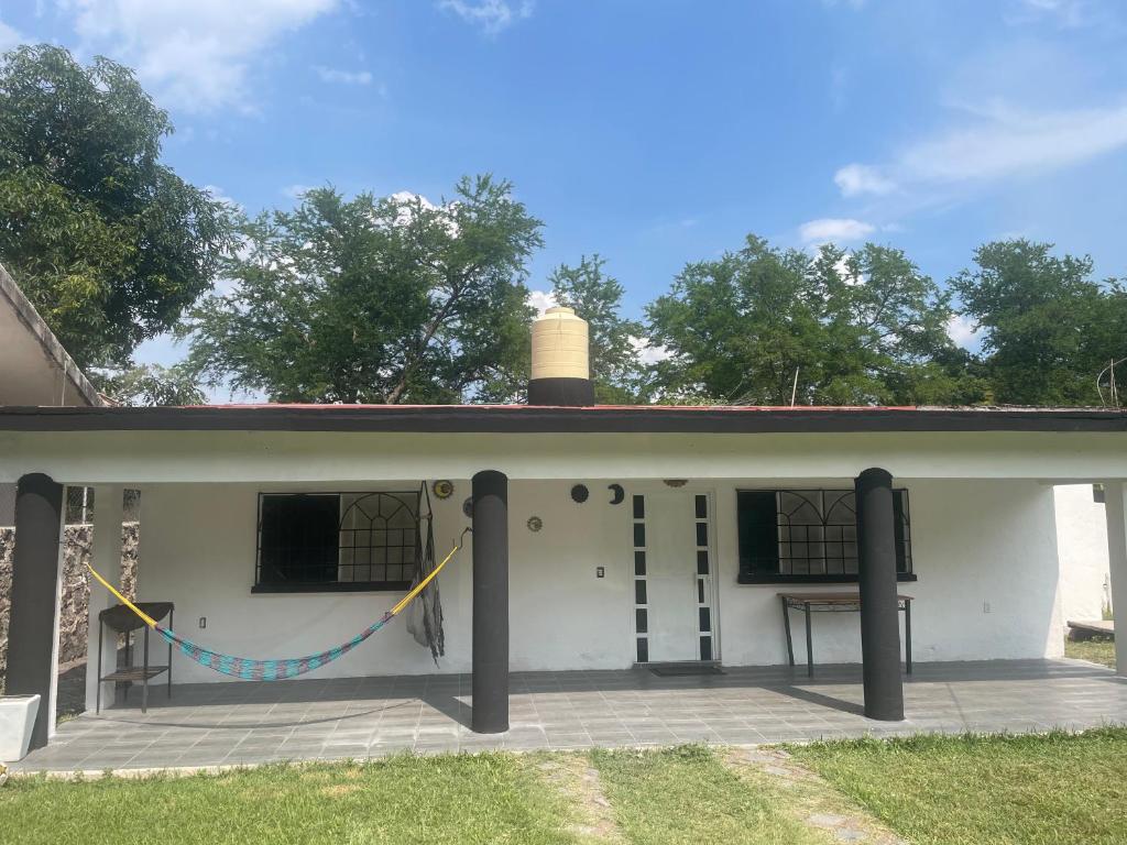 a white house with a porch with a picnic table at Casa fraccionamiento colonos Ticuman in Ticumán