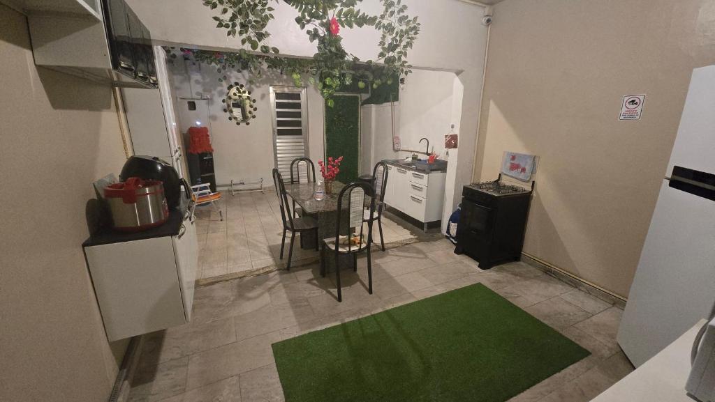 a kitchen with a table and a green rug at Hostel & Privativo in Manaus