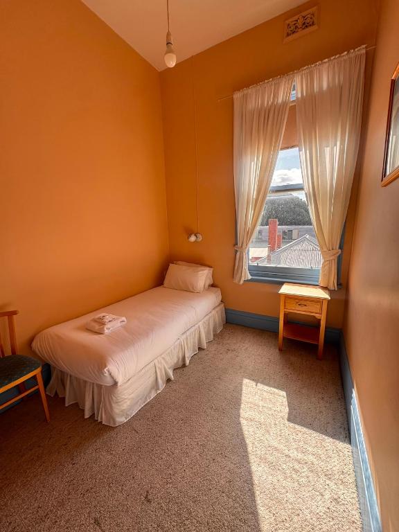a small bedroom with a bed and a window at The Leopold Hotel in Ararat
