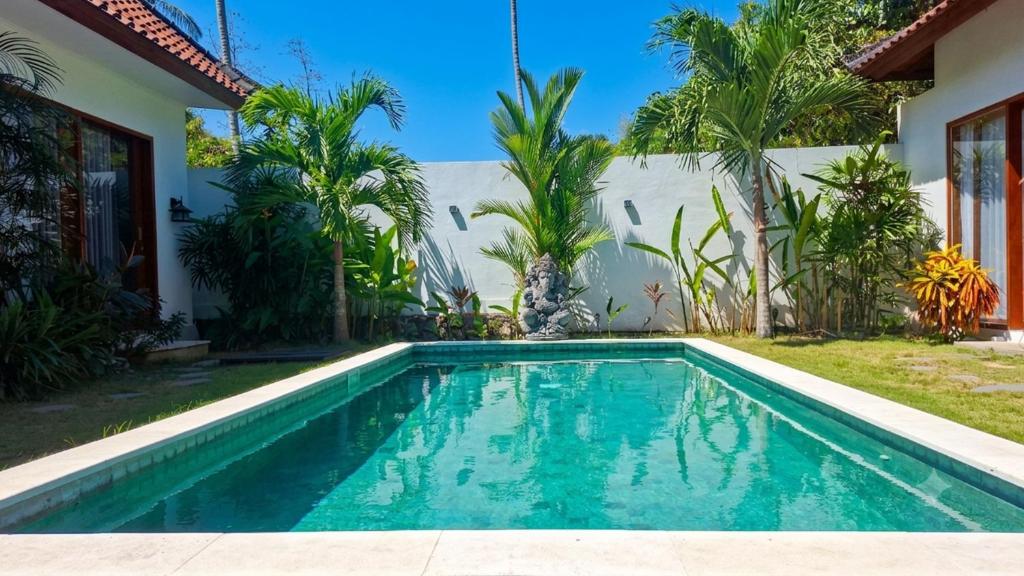 a swimming pool in front of a house at Tropical Villa with Swimming Pool in Selong Belanak
