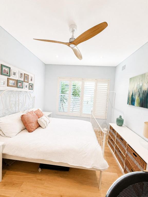 a bedroom with a bed and a ceiling fan at Unique beach flat with own carpark area in Freshwater