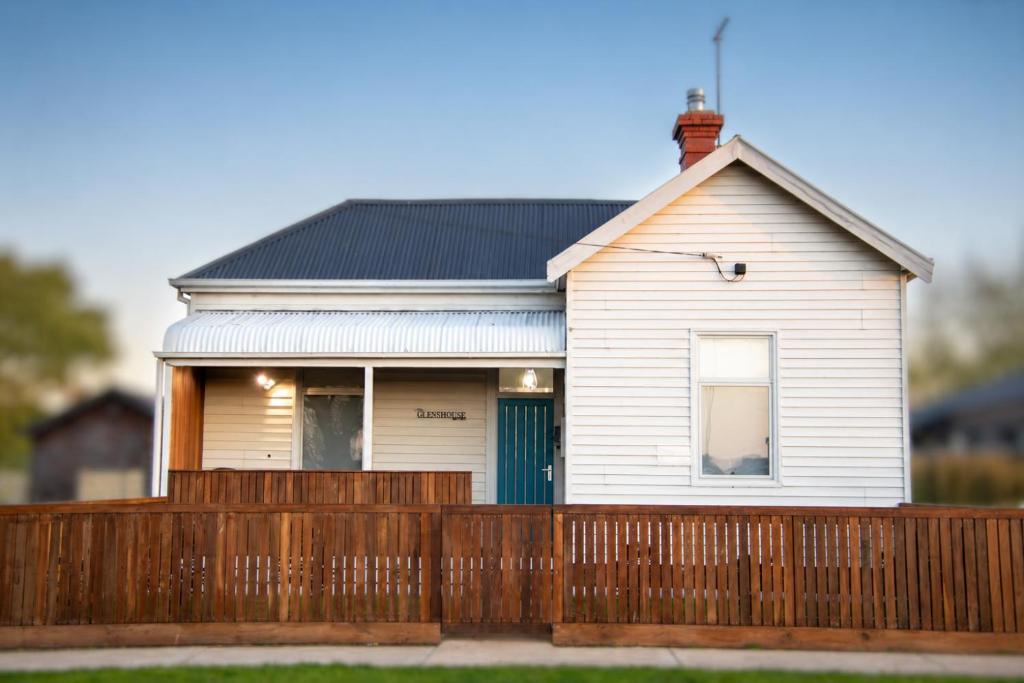 a white house with a wooden fence at The Guesthouse in Terang
