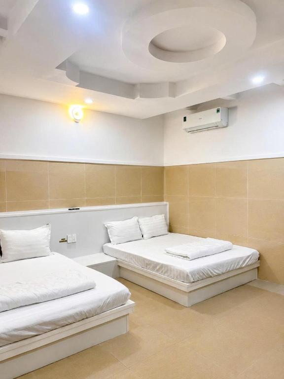a room with two beds and a ceiling at Cảnh Việt Hotel in Tây Ninh