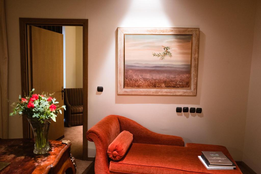 una sala de estar con una silla y un jarrón de flores en Mainalon Resort, en Tripolis