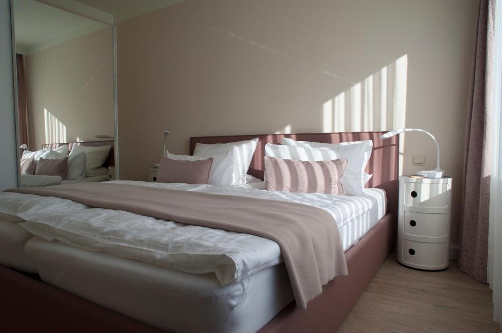 a bedroom with a large bed with pink and white pillows at Antoinettes Ferienwohnung in Ilmenau