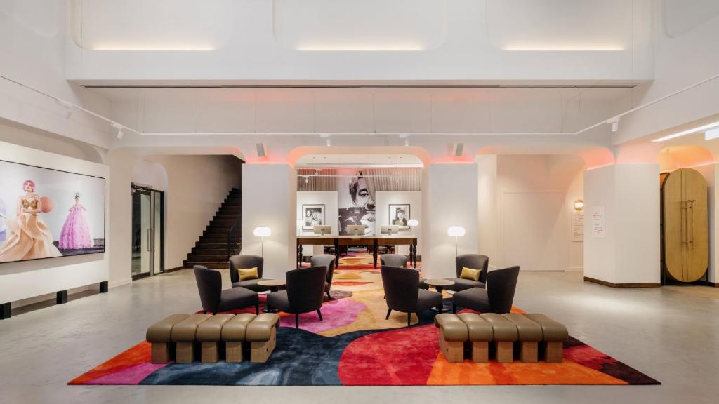 a lobby with chairs and a table and stairs at Hotel Indigo Melbourne on Flinders by IHG in Melbourne